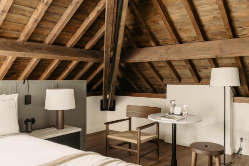 een slaapkamer met een bed, een tafel en een stoel bij august in Antwerpen