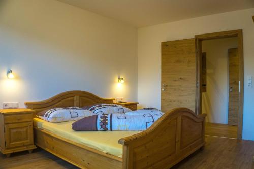 a bedroom with a wooden bed with two pillows at Apart Sporer in Hippach