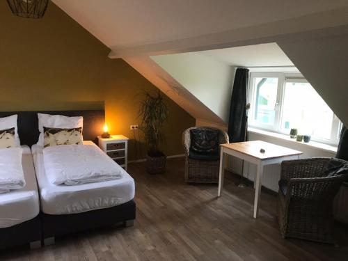 a bedroom with a bed and a table and a window at B&B de Rivierduin in Hattem