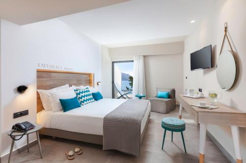 a hotel room with a large bed and a desk at Carian Hotel in Masouri