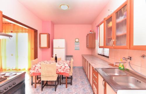 Il comprend une cuisine équipée d'une table et d'un réfrigérateur blanc. dans l'établissement Apartments Danijel 1956, à Pula