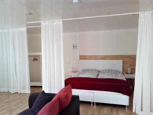 a bedroom with a large bed with a red blanket at Ferienwohnung auf dem Dorf, Külsheim in Külsheim