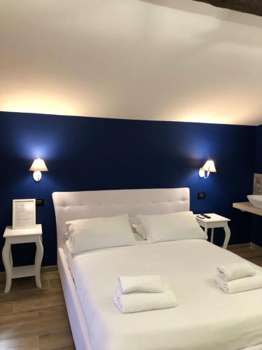 a bedroom with a white bed with two towels on it at Hotel Domus Tiberina in Rome