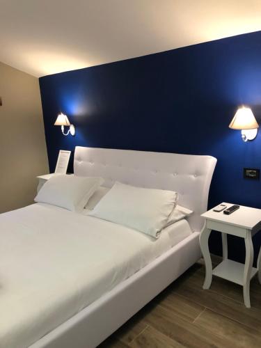 a bedroom with a white bed with a blue wall at Hotel Domus Tiberina in Rome