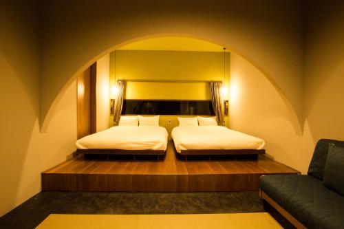 a bedroom with two beds and a couch in it at -Musée Villa- in Nakijin