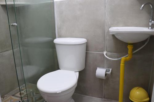 a bathroom with a toilet and a sink at Pousada Liras da Poesia in Porto De Galinhas
