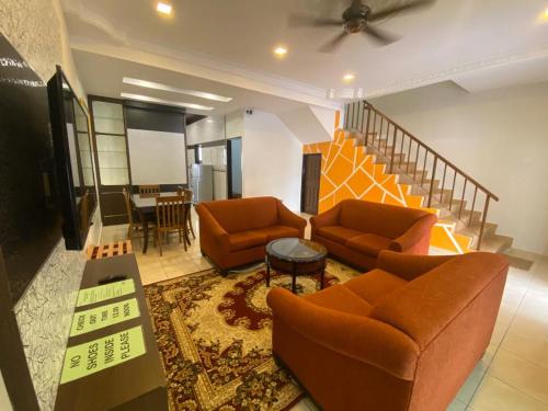 a living room with two couches and a staircase at HILLVIEW HOMESTAY in Tanah Rata
