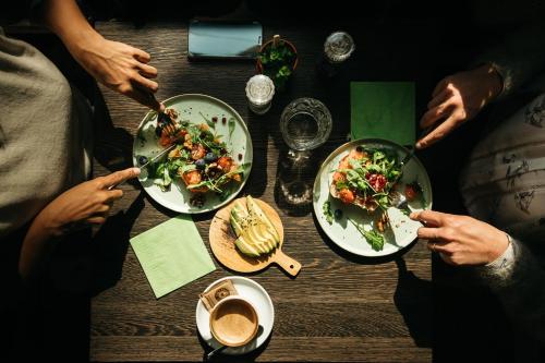 a group of people sitting around a table with plates of food at Charlie's Bed & Breakfast in Antwerp