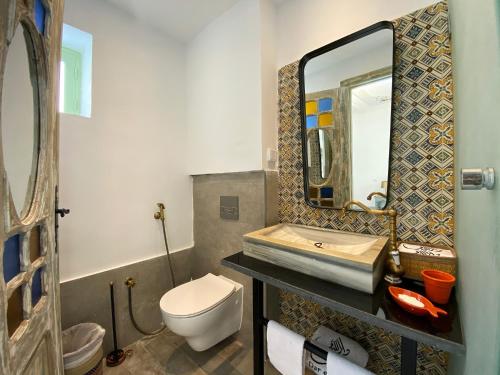 a bathroom with a sink and a toilet and a mirror at Dar El Kif - La Marsa in La Marsa
