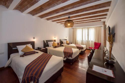 A bed or beds in a room at La Casona Hotel Boutique