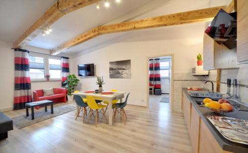een keuken en een woonkamer met een tafel en stoelen bij Apartamenty i Pokoje Karpacz - centrum Karpacza, parking w cenie! in Karpacz