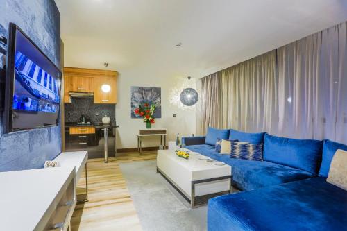 a living room with a blue couch and a tv at SBN Suite Hôtel in Tangier