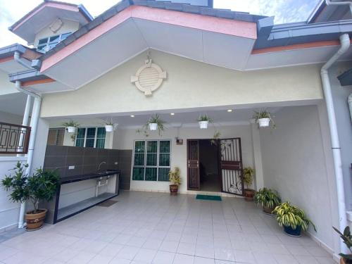 a white house with plants in the courtyard at HILLVIEW HOMESTAY in Tanah Rata