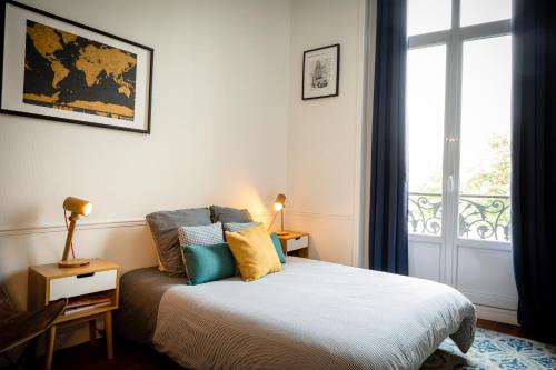 - une chambre avec un lit et une fenêtre dans l'établissement L’Aristide, à Reims