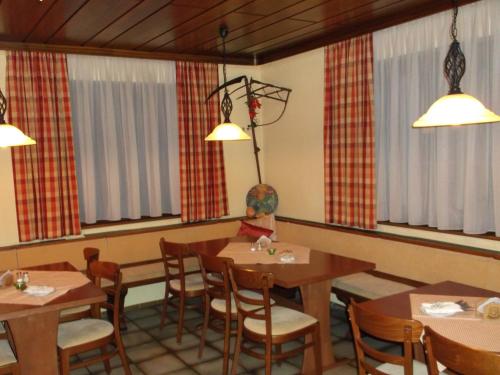 a dining room with tables and chairs and windows at Gasthaus Vogelgarten in Eislingen