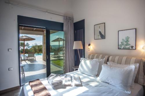a bedroom with a bed with a view of a patio at Premium Ionian Villas - Vlachata in Vlachata