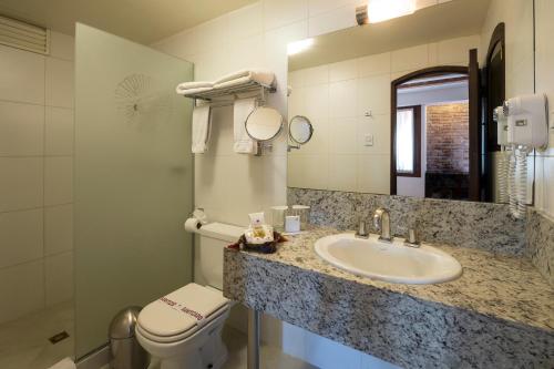 a bathroom with a sink and a toilet and a mirror at La Casona Hotel Boutique in La Paz