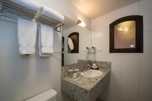 a bathroom with a sink and a toilet and a mirror at La Casona Hotel Boutique in La Paz