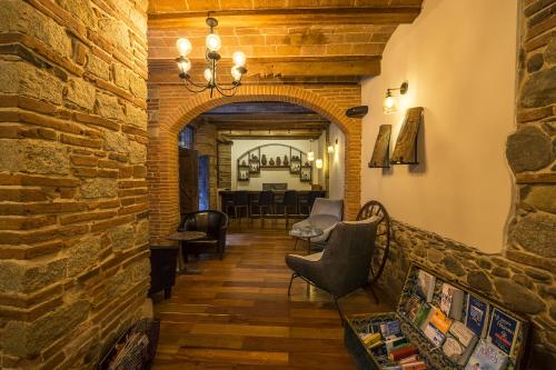 a living room with a stone wall and a chandelier at La Casona Hotel Boutique in La Paz