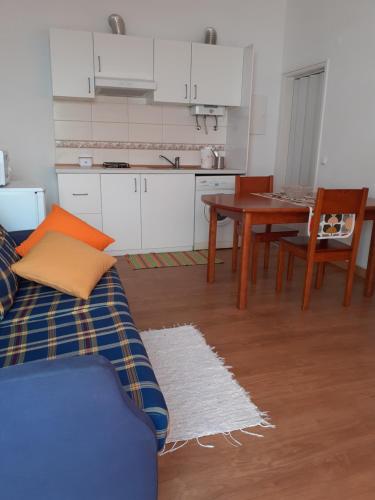 a kitchen and dining room with a couch and a table at Casas Dona Zi in Vila Nova de Milfontes