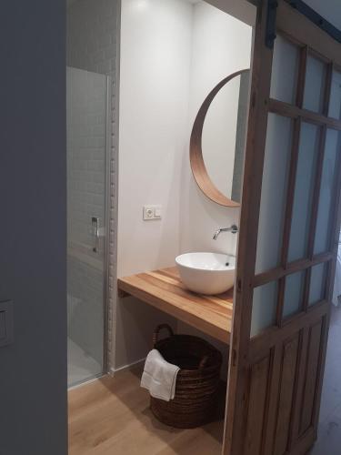 a bathroom with a sink and a mirror at Dos Alas Rojas, casa con jacuzzi para dos personas in Mélida
