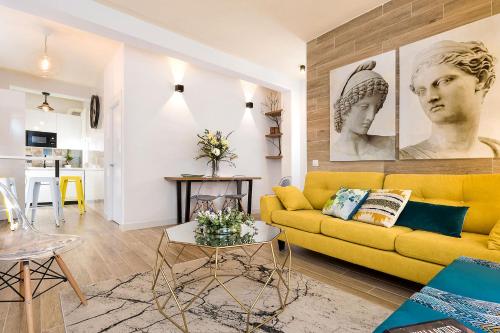 a living room with a yellow couch and a table at Genteel Home Pajaritos in Seville