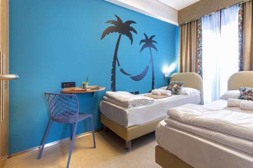 Pokój z 2 łóżkami i niebieską ścianą w obiekcie Costa Rica Bibione Aparthotel w Bibione