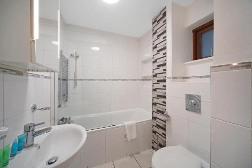 a bathroom with a tub and a sink and a toilet at 2 Bed Chic Apartment near Shoreditch & Liverpool St FREE WIFI & PARKING by City Stay Aparts London in London