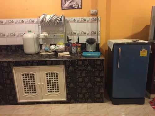 a kitchen with a counter with a blue refrigerator at บ้านศรีสมบูรณ์ เชียงคาน in Chiang Khan