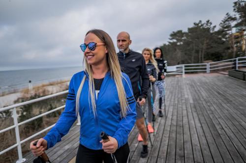 a group of people walking on a boardwalk at Hotel Bryza Resort & Spa in Jurata