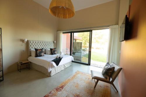 a bedroom with a bed and a large window at Marianne Wine Estate in Stellenbosch