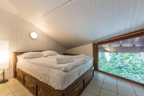 une chambre avec un lit avec une grande fenêtre dans l'établissement Apartment Les Avouilles Close to Chamonix Mont Blanc, à Chamonix-Mont-Blanc
