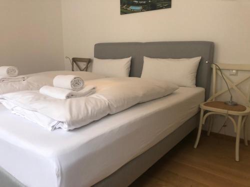 a bed with white sheets and towels on it at Apartment Seeglück am Schliersee - modern, zentral, perfekt für Familien in Schliersee