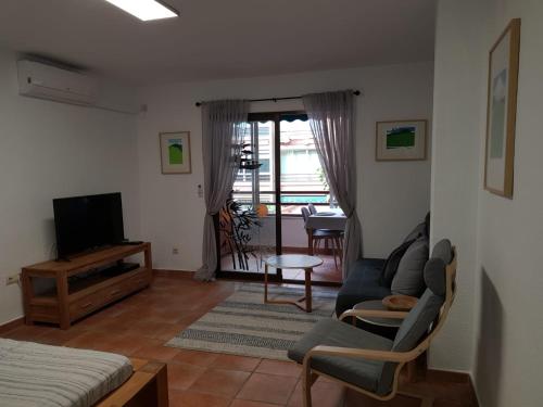 a living room with a couch and a tv at Estudio en el centro de San Juan de Alicante in San Juan de Alicante