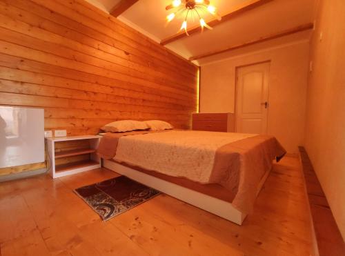 una camera con un letto in una stanza con pareti in legno di садиба Пан Коцький a Kosiv