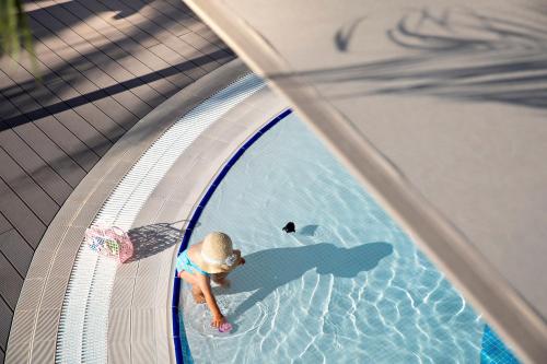 an overhead view of a child in a swimming pool at ROBINSON QUINTA DA RIA - All Inclusive in Vila Nova de Cacela
