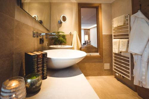 hotel & chalet madlochBlick في ليش ام ارلبرغ: حمام مع حوض استحمام أبيض كبير ومغسلة