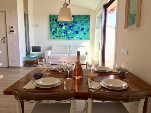 a dining room table with wine glasses and a couch at Barcuzzi in Barcuzzi
