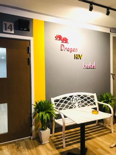 a white bench in a room with a sign on a wall at Dragon XIV in Bangkok