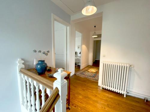 a living room with a staircase and a room with a hallway at Les Chambres de LOUIS in Le Chesnay