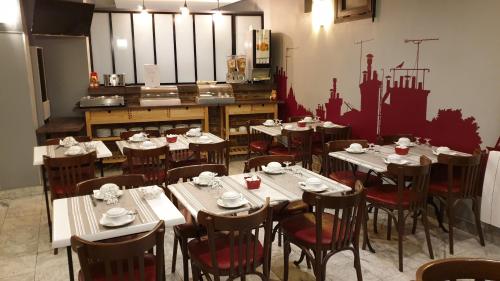 a dining room with tables and chairs in a restaurant at Hotel Paris Villette in Paris