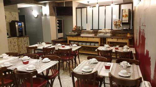 a restaurant with tables and chairs and a kitchen at Hotel Paris Villette in Paris