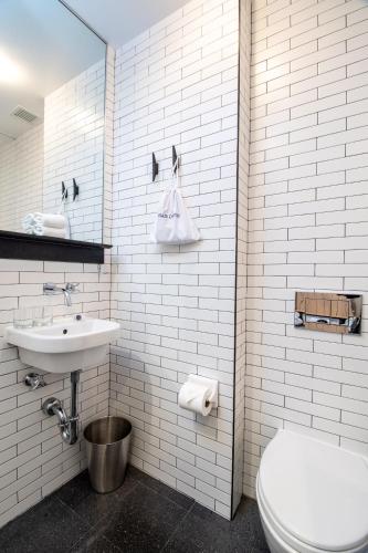 a white bathroom with a toilet and a sink at Pod 39 in New York
