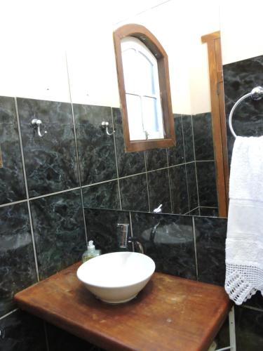a bathroom with a sink and a mirror on a counter at Casa Rô in Tiradentes