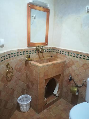 a bathroom with a stone sink and a mirror at Dar Pa Labzioui in Meknès
