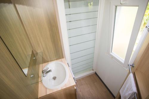 a bathroom with a sink and a window at Camping du Château Vert in Hondainville