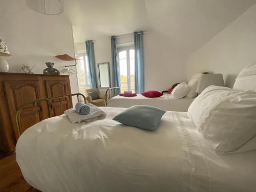 a bedroom with two white beds and a window at Les Chambres de LOUIS in Le Chesnay