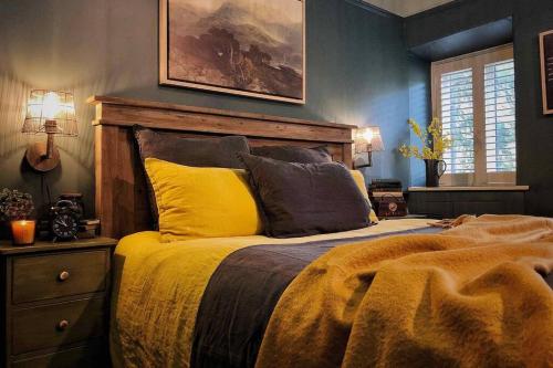 a bedroom with a bed and a painting on the wall at CELYN - SNOWDONIA COTTAGE in Caernarfon