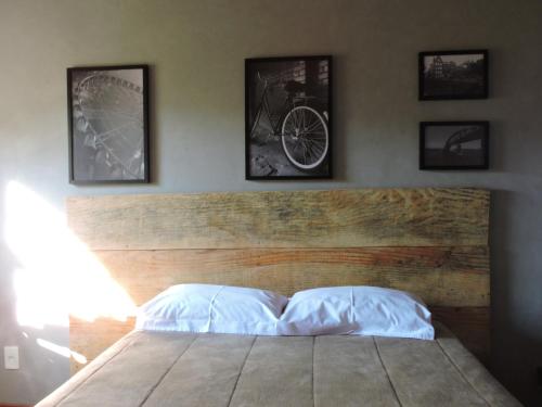 a bedroom with a bed with four pictures on the wall at Casa Rô in Tiradentes