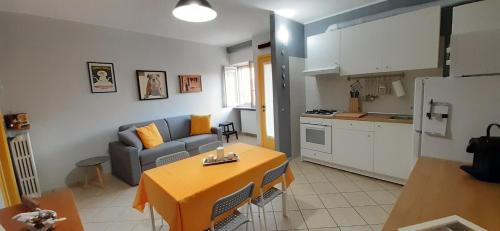 a kitchen and a living room with a couch and a table at Corte del sole in Dormelletto